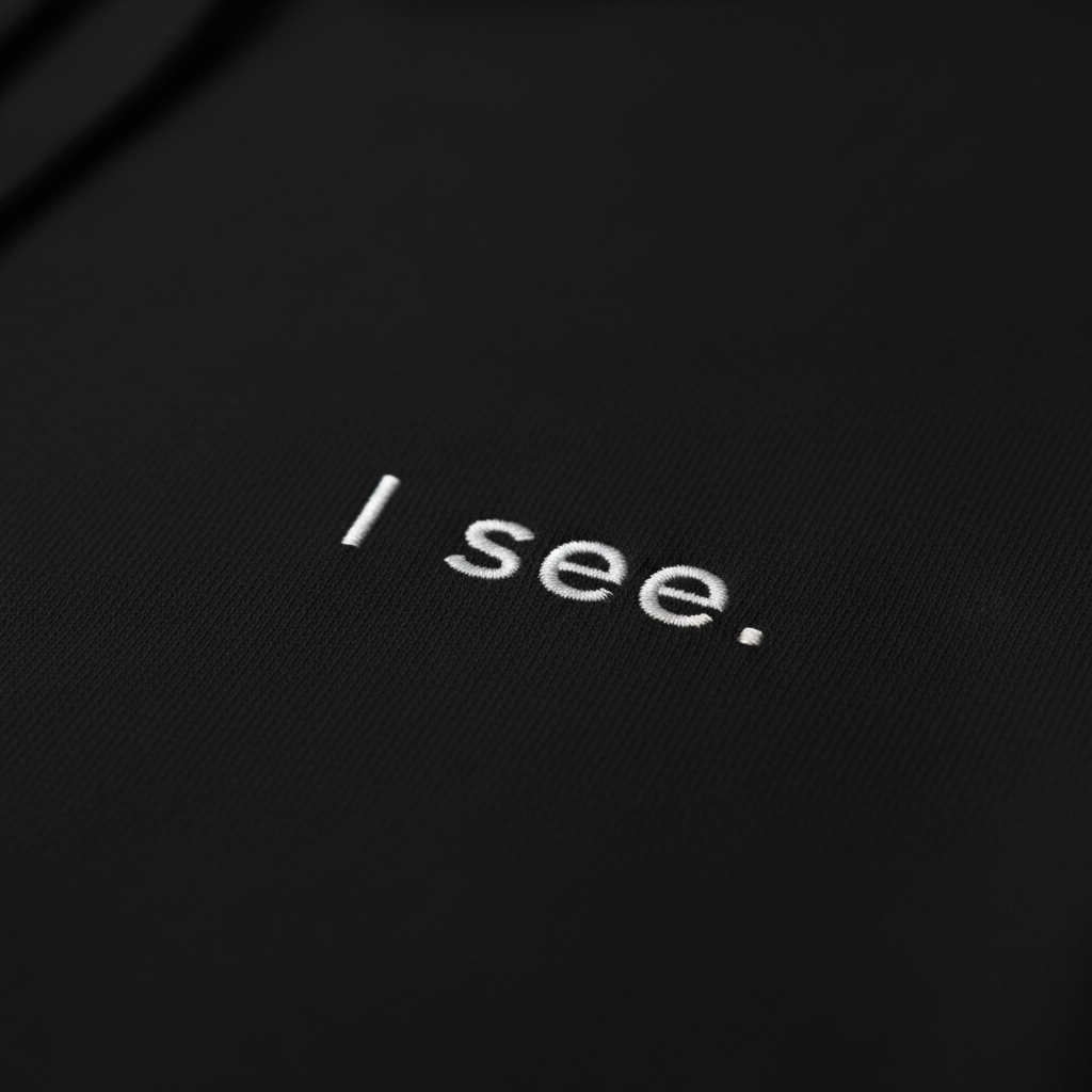 Close-up of black hoodie fabric and print detail, premium texture and clean typography
