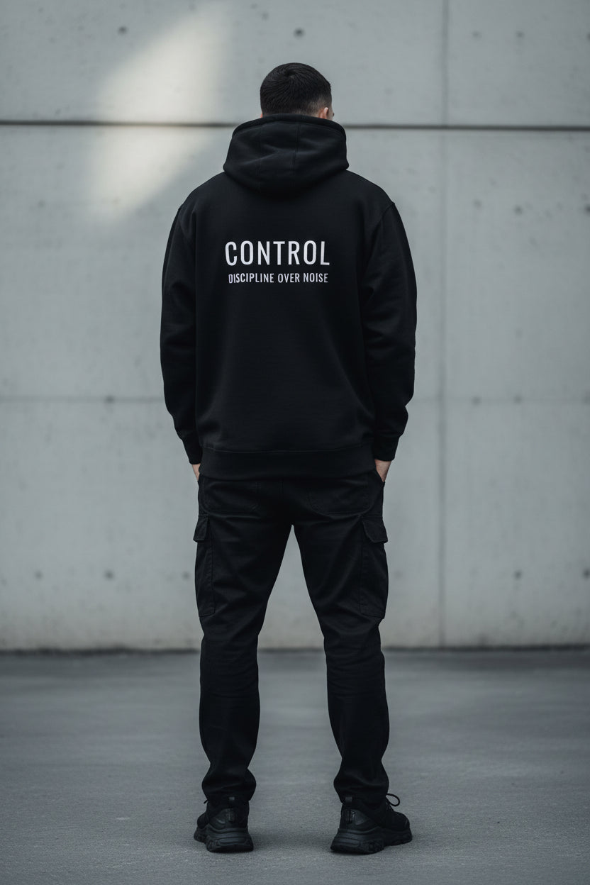 Black oversized CONTROL hoodie with Discipline Over Noise statement in cinematic night setting