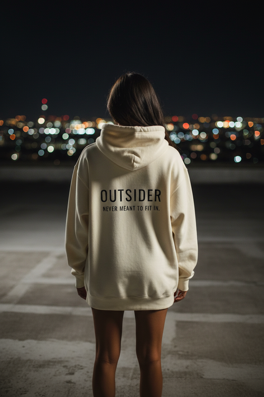 Woman wearing oversized cream statement hoodie in cinematic streetwear aesthetic